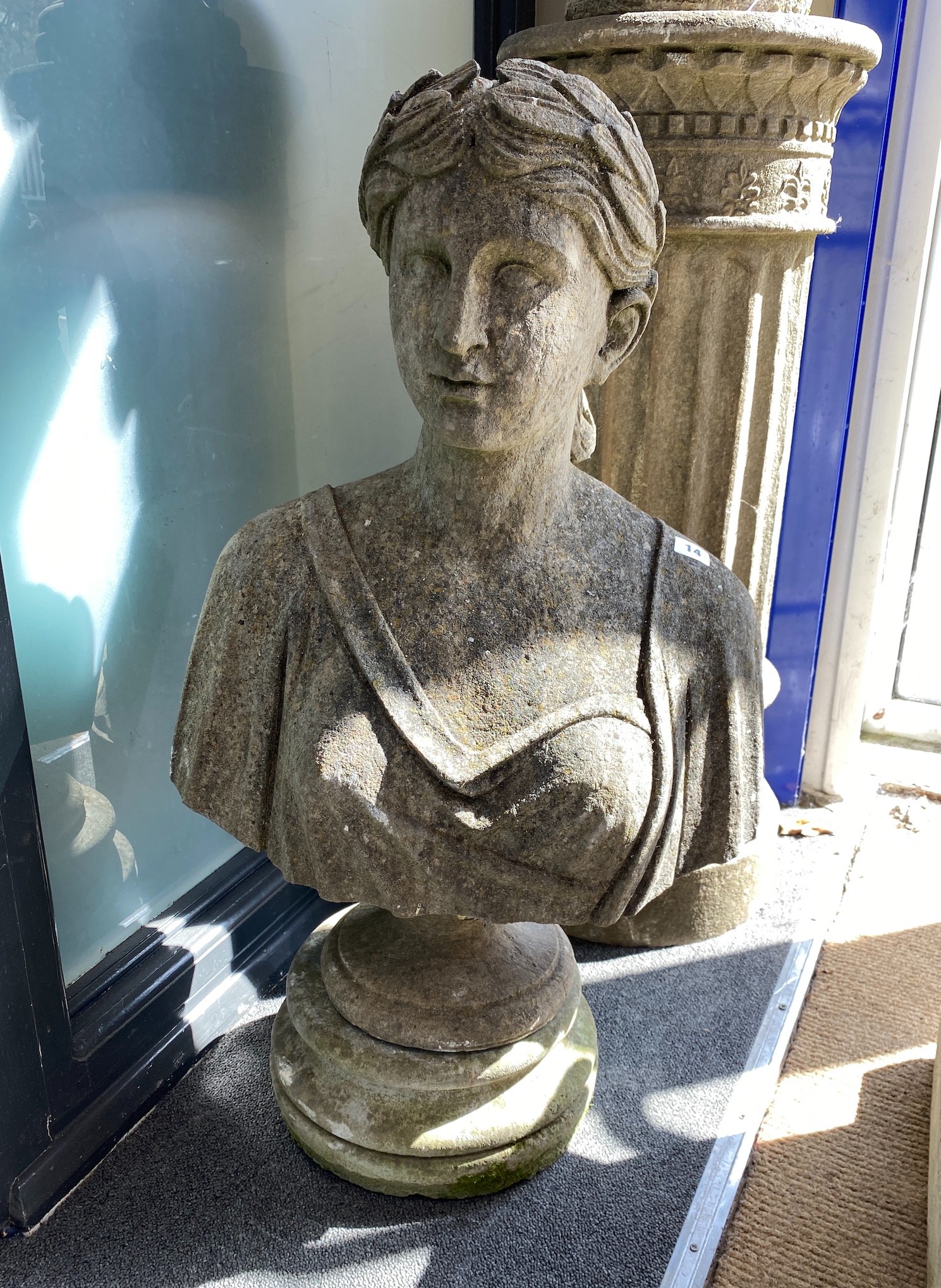 A reconstituted stone female bust on shallow plinth, height 83cm